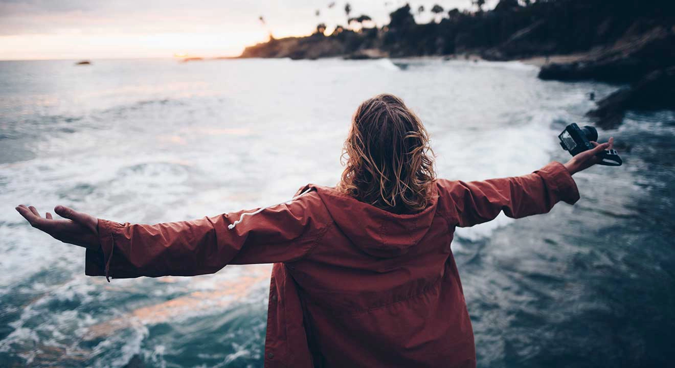 A woman with her arms outstretched on the water side