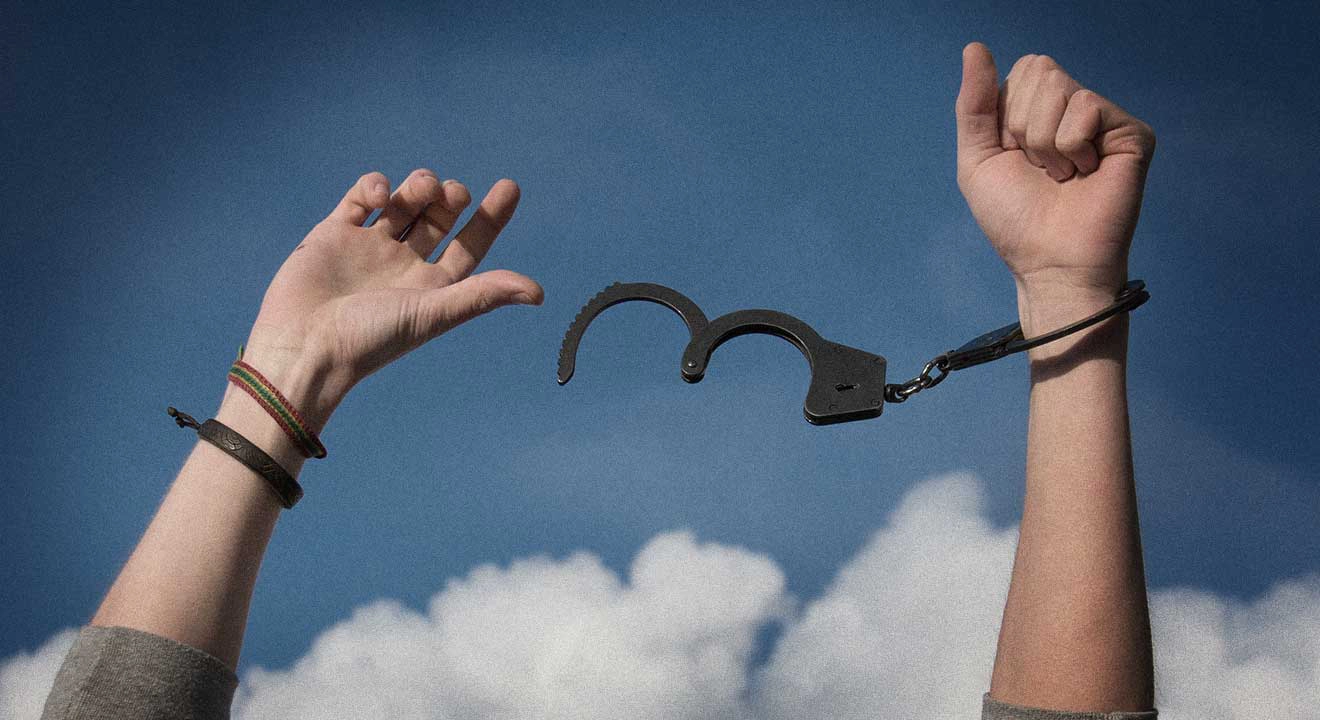 A man with hands in the air and unlocked handcuffs