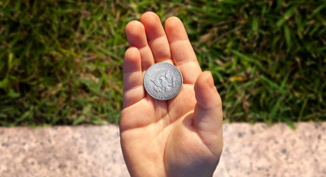 A man's hand holding a coin tails up