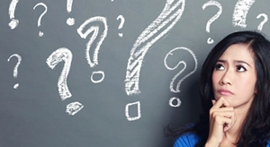 Woman with her hand on her chin looking at question marks