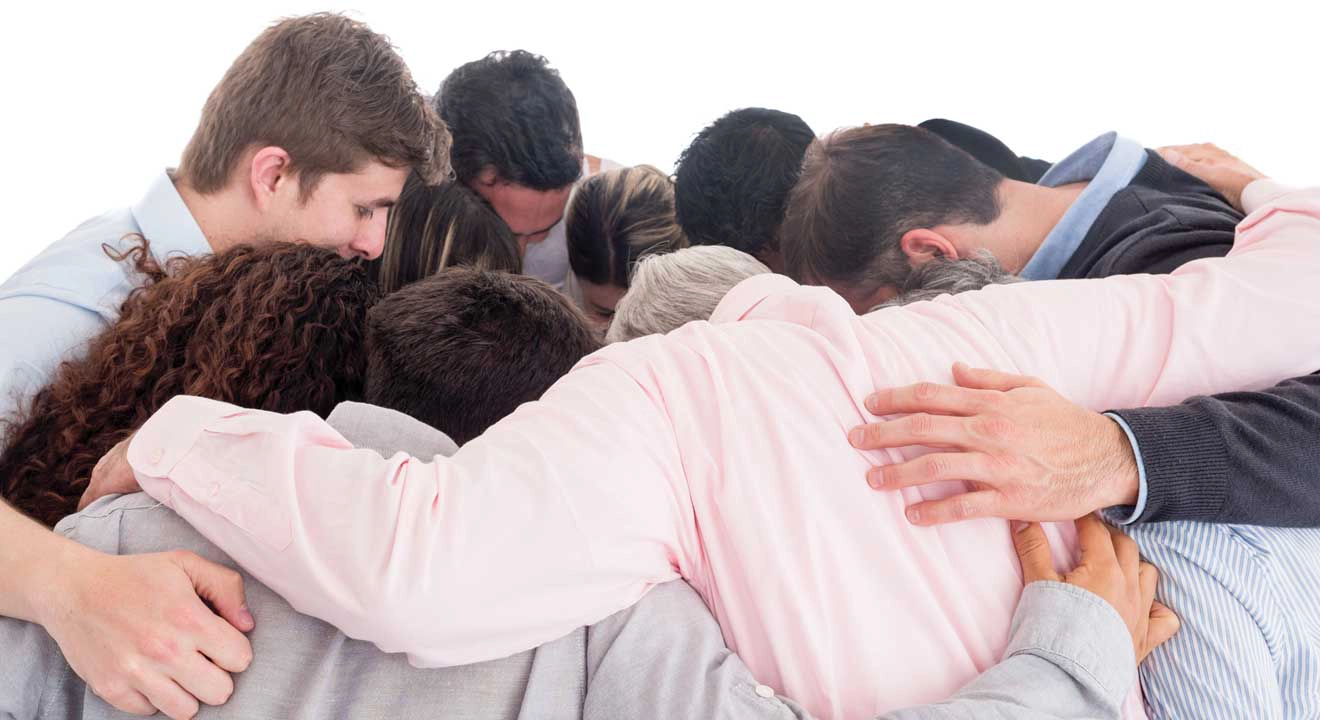 Group huddle of men and women praying