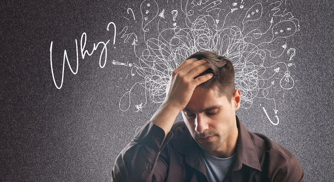 A man with his hand in his hair and text asking Why?