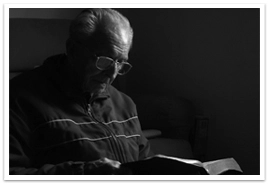 An elderly man reading a Bible