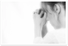 Three quarter view of young lady folding hands in prayer