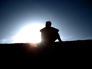 A man leaning back watching the sun rise