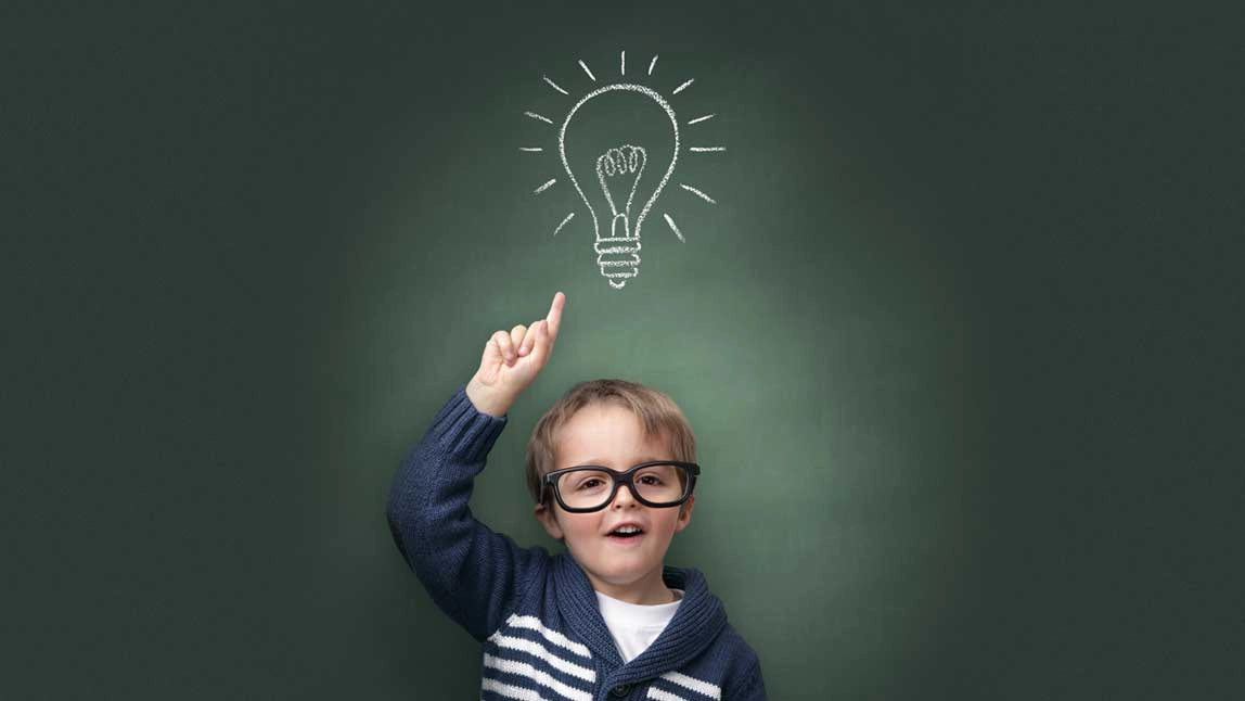 A you boy with glasses pointing up to a drawn light bulb