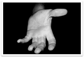 An outstretched hand open in the darkness