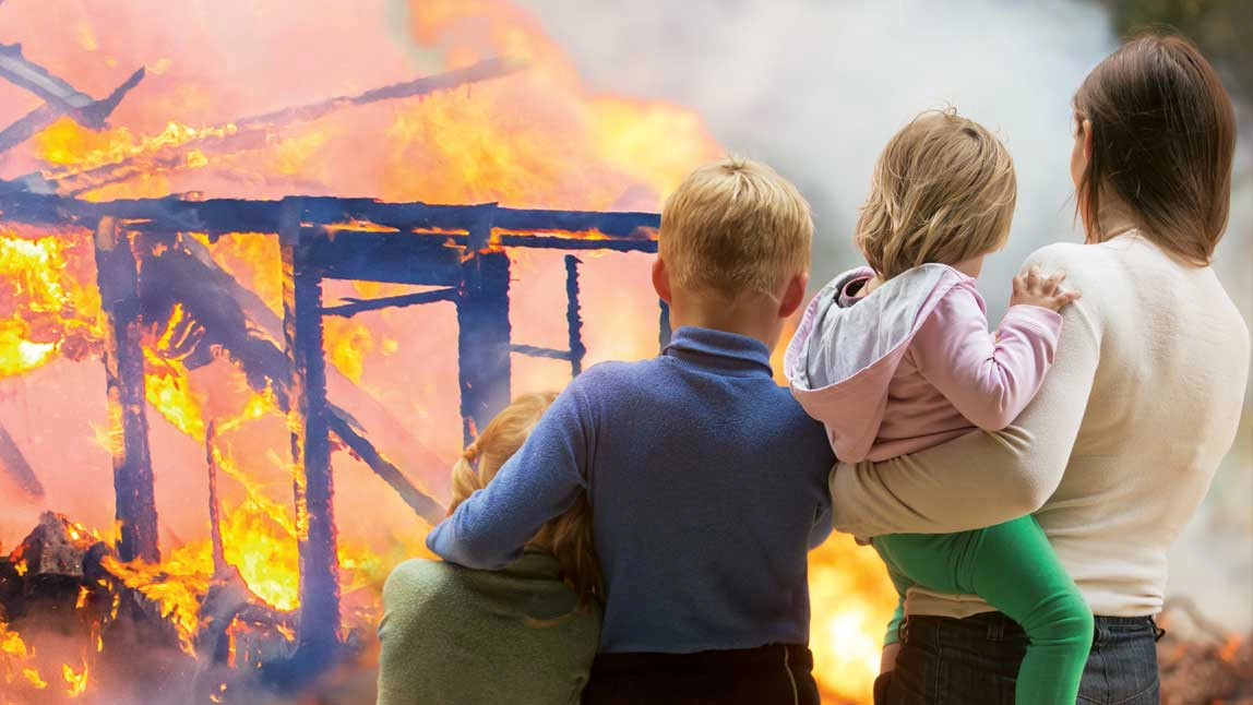 A young family looking on as their house is burning