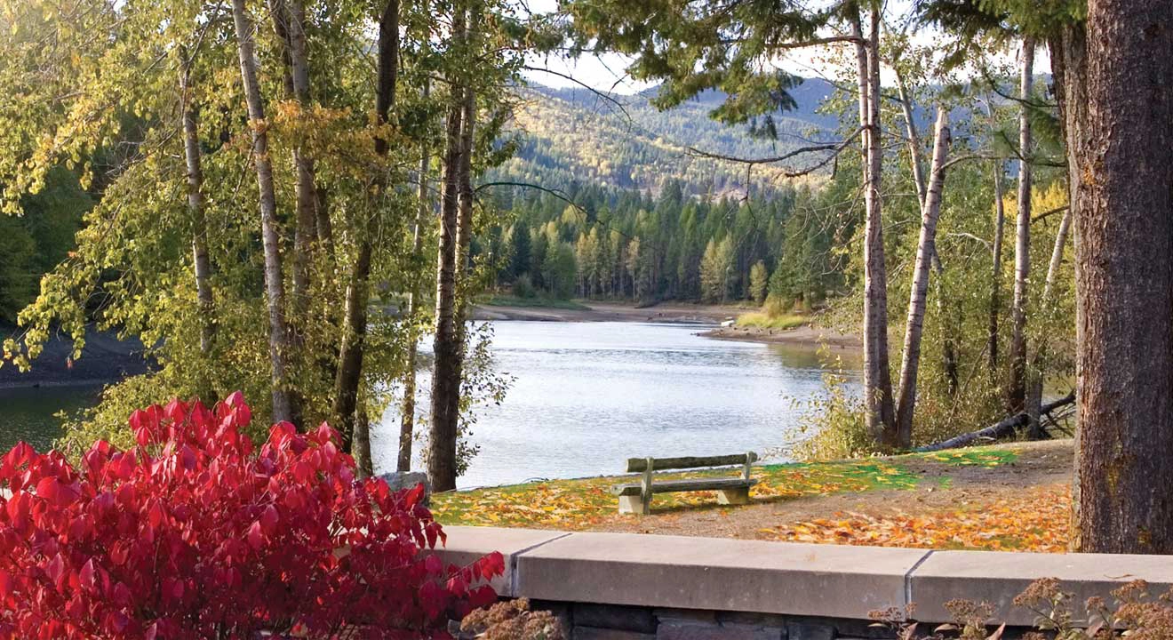 A park bench overlooking a lake in the mountains