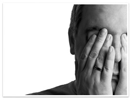 A man with his hands covering his eyes