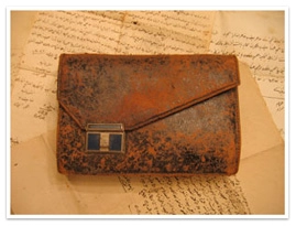 A leather journal with a clasp on hand-written letters