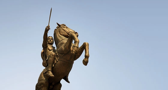 A man with a sword raised upward on a horse