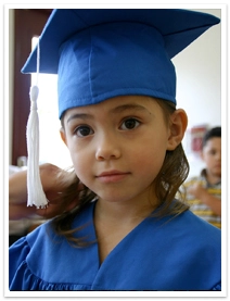 A young girl wearing a cap and gown