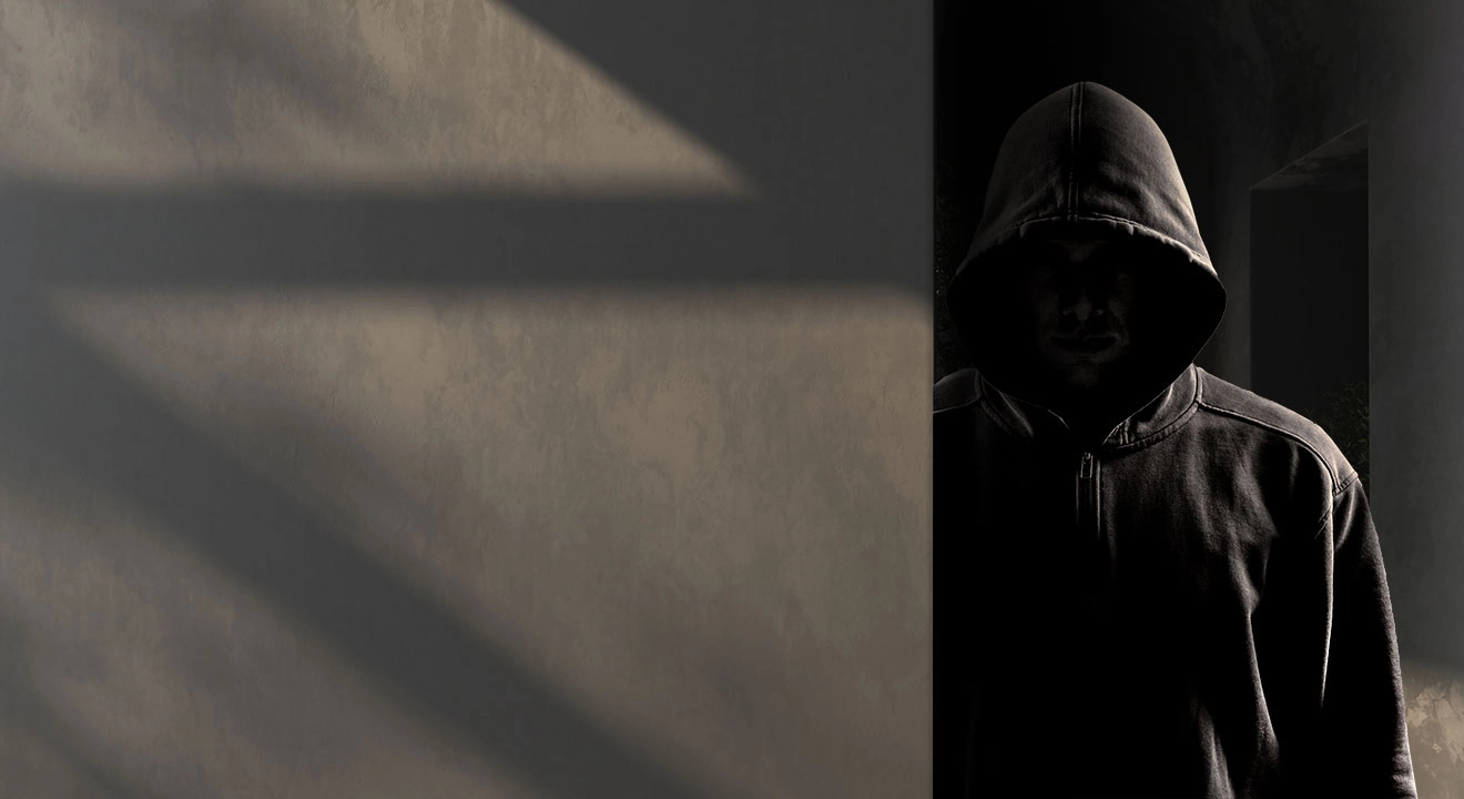 A hooded figure lurking in the shadows