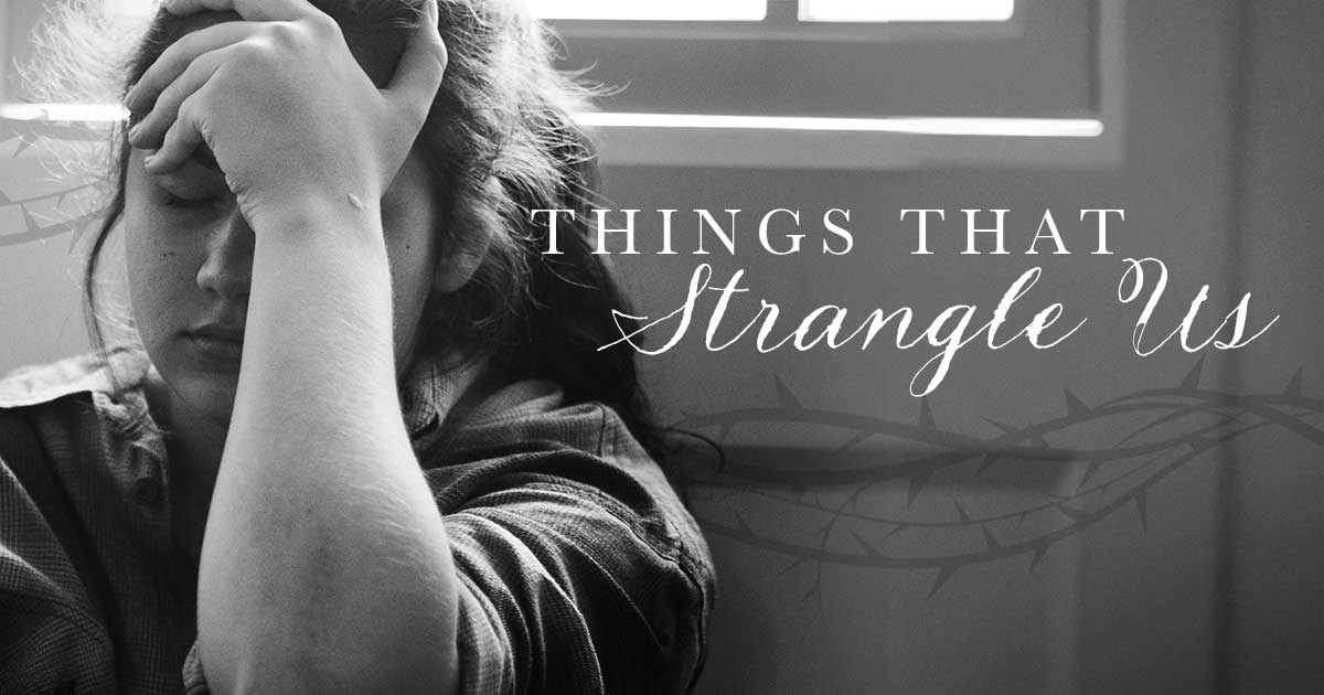 A young lady sitting on the floor holding her forehead with her hand