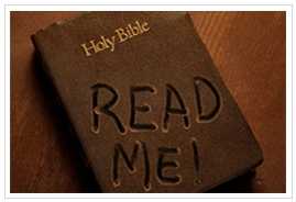 A dusty Bible with "Read Me!" written on it