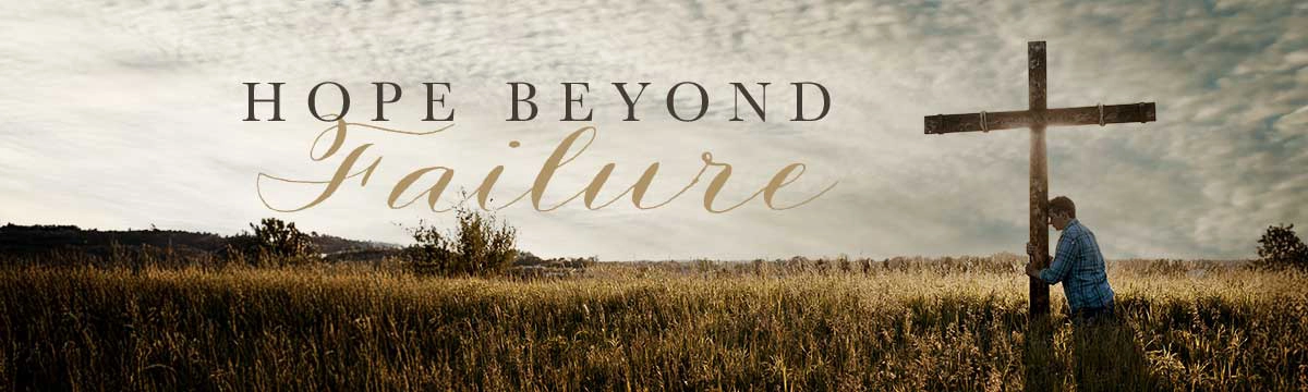 A man holding a cross in a field