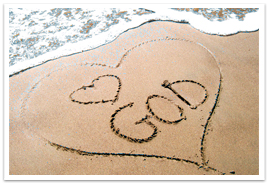 A heart drawn in the sand with a heart GOD on a beach