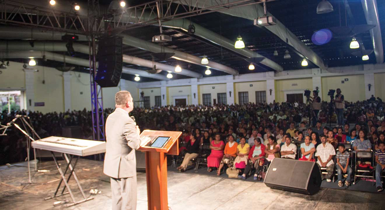 Carlos Zazueta speaking to an audience in a large room