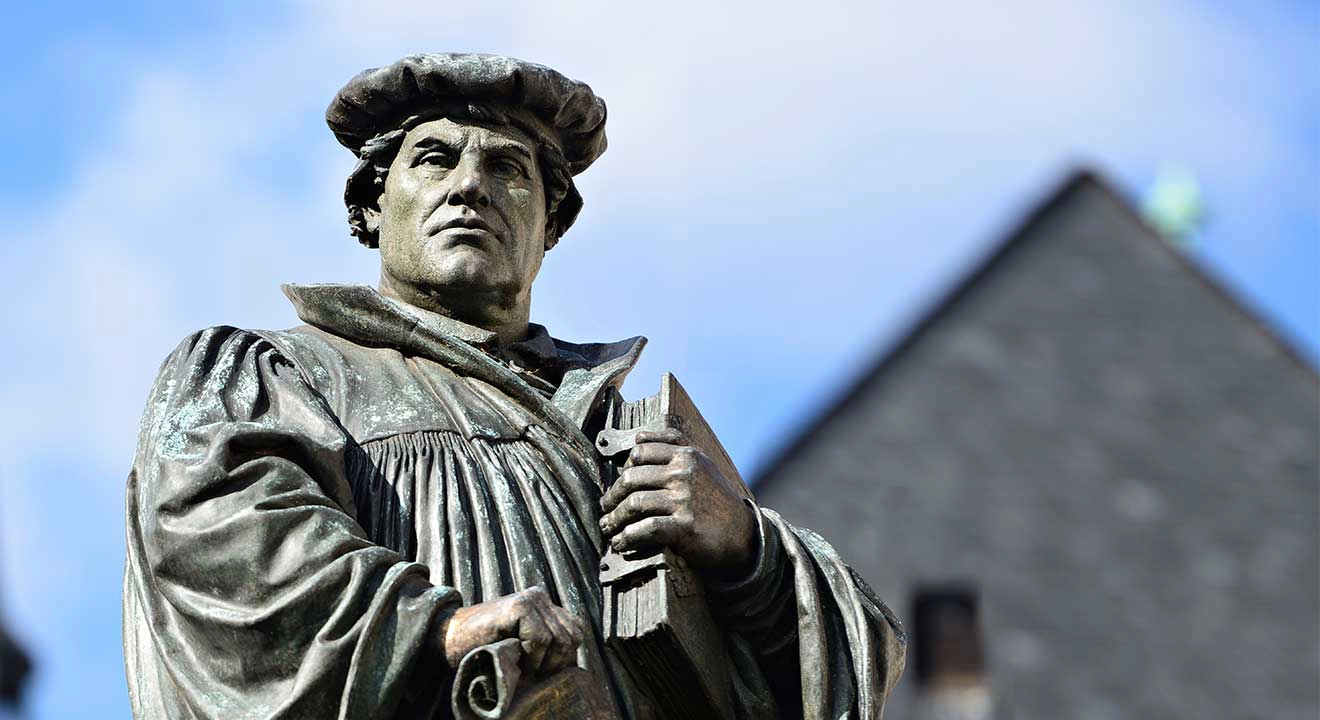 A statue of Martin Luther in front of a building